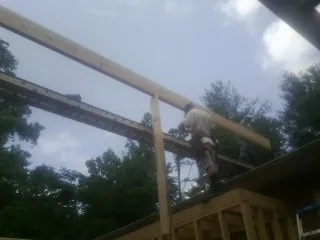 Carpenter setting a ridge beam over a new addition frame — Ice Dam Removal by Roofing Brothers in Frackville