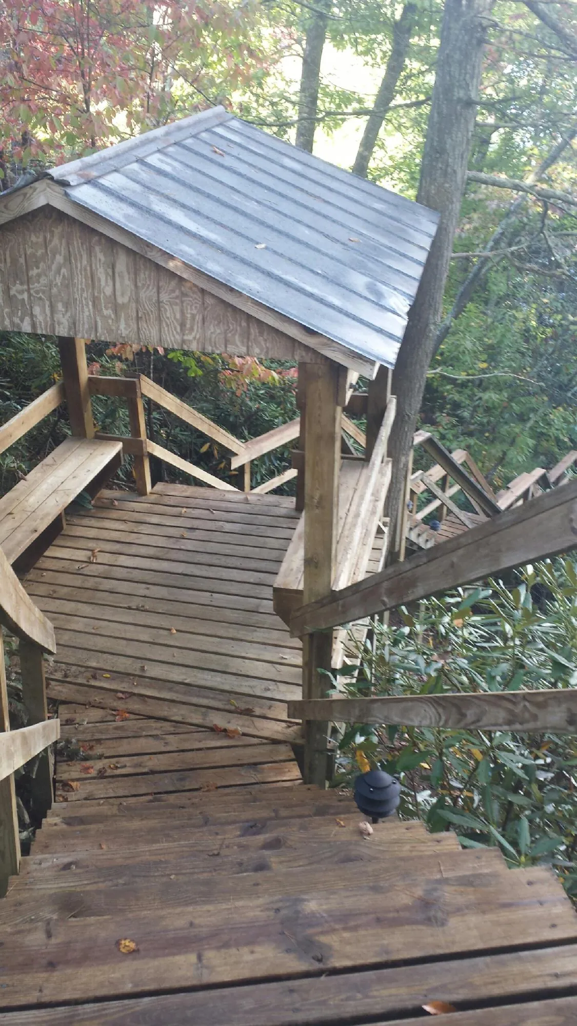 Metal roofed shelter over wooden steps on a wooded walkway — Skylight Repair & Installation work by our crew in Frackville